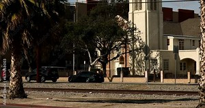 Maywood, California, USA - February 11, 2023: Afternoon sun shines on palm trees and buildings of Downtown Maywood.