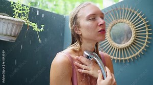 Wet woman, stands in an open shower, in the rain, enjoys shower, slow motion Stock Video