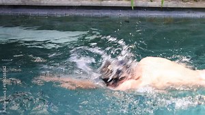 Young man swimming on private swimming pool. Daily workout.
