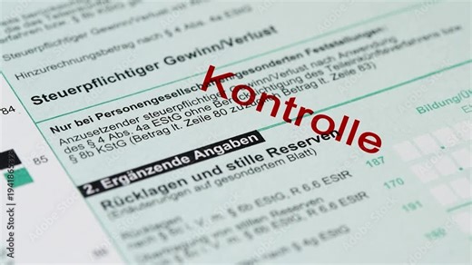 Ein Formular zur Einkommensteuer wird vom Finanzamt mit einem Stempel markiert - FOTOMONTAGE