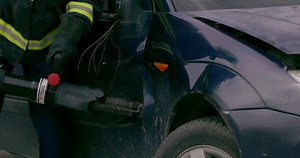 A skilled team of firefighters employs specialized tools and quick reactions to successfully extricate a person trapped in a car, showcasing their heroism and precision in a high-stakes rescue
