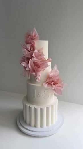 A couple of weeks ago, we sent out this beautiful four-tiered cake with a scallop shape at the base and the couple’s initials in white. It’s got that classic, timeless vibe, with some wafer paper and rice paper details on the top and middle tiers. The pop of baby pink just adds something special, making it feel really fresh for the wedding | K CAKE