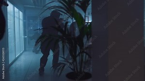 Masked Squad of Armed SWAT Police Officers Storm a Dark Seized Office Building with Desks and Computers. Soldiers with Rifles and Flashlights Move Forwards and Cover Surroundings.