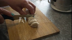Traditional Manty Making: Hands-On Craftsmanship. Hands cut pieces of dough from a long strip.