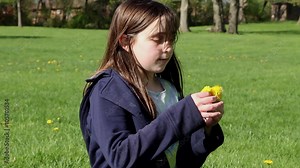 A young girl picking flowers in the park