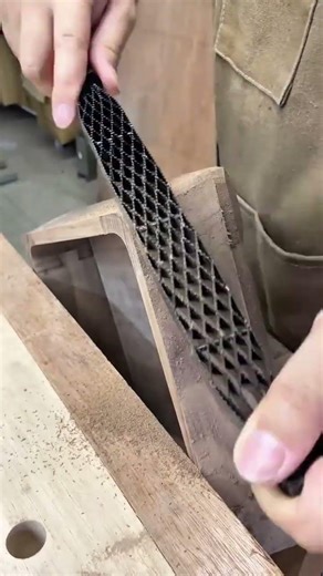 Smoothing and shaping wood surfaces with a metal hand rasp to create curved edges and fine finishes