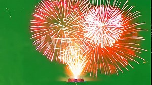 Fireworks Display on Green Screen: Two vibrant fireworks burst against a chroma key green screen, their sparks and trails illuminating the night.