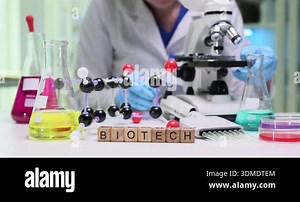 Wooden cubes spell word Biotech near colorful molecule model. Scientist in laboratory explores genetic engineering and pharmaceutical innovation