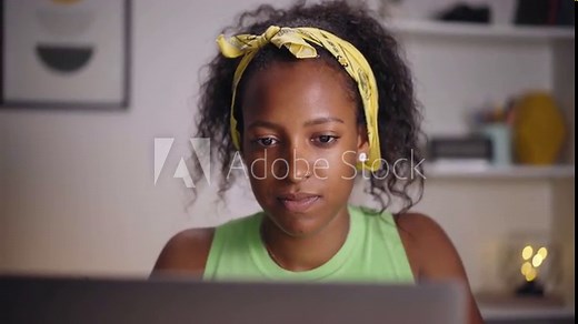 Video close up young American woman using laptop in home office. Happy girl looking at computer screen. Concentrated people in a studio. Concept of entrepreneur and hard working person.