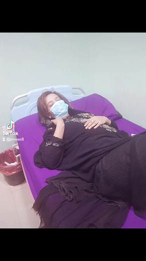Woman in Black Dress Resting in Hospital Room