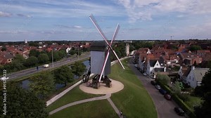 Exploring a historic windmill in Belgium surrounded by quaint village homes and scenic landscapes