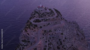 Drone view of Mallorca famous lighthouse located on top of a cliff during sunrise, aerial