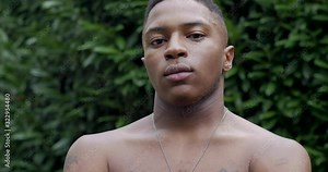 Shirtless young black man looking sternly like a thug at the camera