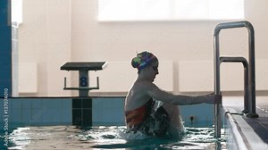Female swimmer gets out of the pool on step ladder after swimming HD slow-motion video. Professional woman athlete climbs from water. Stock Video