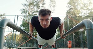 Engaging in the dynamic pushup exercise on parallel bars requires strength, balance, and technique