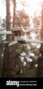 A flying drone captures stunning views of tall trees and nature in a serene forest setting during daytime.