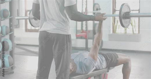 Vertical video: Coach checking grip and supporting bar as trainee pressing bench bar safely in gym