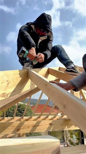 Efficient Construction Worker Using Impact Driver to Secure Wood Beams Outdoors