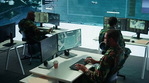 Military personnel in a high tech command center monitor satellite feeds, coordinate intelligence operations. Maintaining national security and supporting strategic army missions. Camera B.