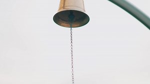 Close-up of a hanging bell with chain