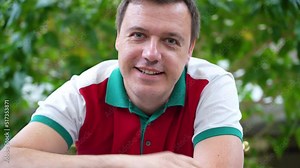 Web cam view of millennial man greeting by waving hand and friendly smiling at camera, saying hi, welcome gesture in friendly manner.