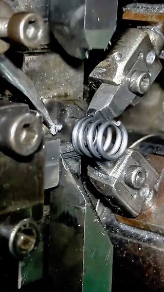 Machine precisely coiling metal wire into spring