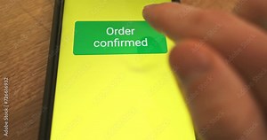 Pressing the Pay Now button on the smartphone screen. Order confirmed, response to purchase of goods, concept of online payment, online store. Close-up, front view.