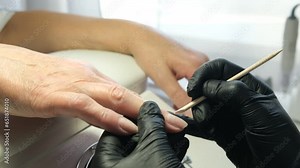 Female hands and tools for manicure, process of performing manicure in beauty salon. Nail care procedure in a beauty salon. Gloved hands of a skilled manicurist cutting cuticles. Concept spa body care