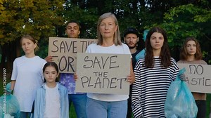 Group Multiethnic Eco Activist Standing in the Park with Garbage and Posters Save Our Planet, No Plastic, Save Forest. Diverse Volunteers Protesting Against Earth Garbage Pollution. Recycle Rubbish