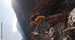 Epic inspiring video of motivating hiker during exploration hike camping trip climbs up mountain ridge Overcoming obstacles travel difficulties, perseverance, will, courage. Vertical video cinematic