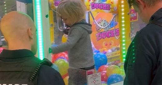 Watch: Smiling toddler gets stuck inside claw machine while parents aren't looking