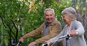 Happy, fun and mature couple talking while walking in a park together, happy and excited to go on a bike ride outdoors. Active seniors enjoying healthy activities while bonding and being cheerful