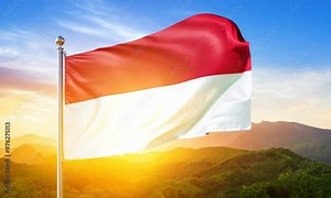 The Indonesian flag, with its red and white stripes, waves beautifully against a sunrise background. This vibrant scene represents Indonesia strength, unity, and rich cultural heritage