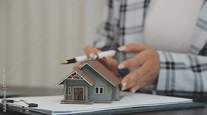 Real estate brokerage agent Hand over the house to the customer and sign the contract agreement home insurance concept Making lease and buying a house