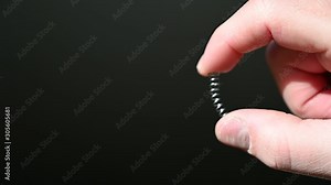 finger and thumb compressing a metal spring Stock Video