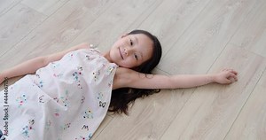 Happy little girl lying on floor,4K