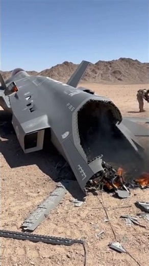 A close-up view of the charred and smoking fuselage of a crashed F-35