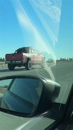 Semi truck driving by Acuity Flag, & a dump truck loosing his load.