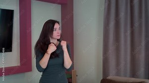 Young girl housewife in an aggressive state boxing at home in the air in slow motion.