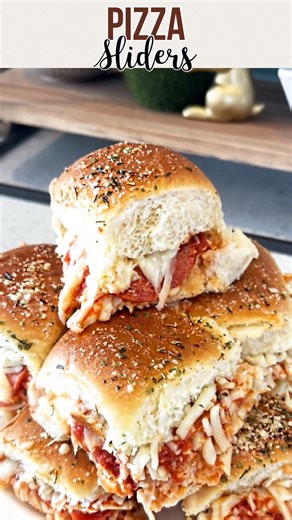 Pizza Sliders are a quick and easy way to make pizza using pull-apart buns! 🍕✨ Ingredients * 12 count package Hawaiian rolls * 2½ cup shredded mozzarella divided * ¾ cup pizza sauce * 12-24 pepperonis * 1 tbsp butter * 2 tbsp grated parmesan * 1 teaspoon dried Italian seasoning Instructions 1. Keep the rolls connected and slice the bread in half, horizontally. 2. Remove the top half of the connected buns and set aside. 3. Place the bottom half of the connected buns in the prepared baking dish. 