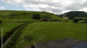 Machynlleth sheep farm in Wales with drone video moving over barn and forward.
