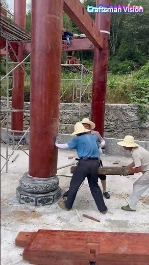 Wooden house pillar construction: Installing giant wooden pillars on stone plinths