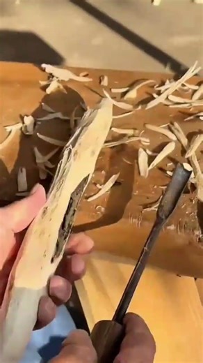 carving a decorative wooden object from a piece of scrap wood using a sharp hand chisel and hammer
