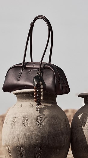 Yore Toast Bag, inspired by the baguette’s shape, adopts a full, pillow-like design with smooth, rounded edges and flowing lines. The bag in Ebony is made of soft, durable, and lightweight first-layer Nappa cowhide, this leather undergoes processes such as water dyeing, color spraying, and color fixing, showcasing a deep reddish-brown from a distance and a blend of black and red up close. Find the Yore Toast Bag on Songmont official.com #songmont #songmontyorecollection #yoretoastbag #eastwestba