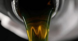 clip-3501375247-pouring-engine-oil-black-bottle-into-change