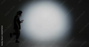 Dancing young girl performing fiery hip hop dance to music in spotlight. Contemporary dancer, rap youth culture