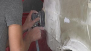 Car body sander. The master is sanding the car body with the help of the device. Industrial mechanic.