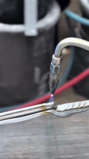 welding two metal rods together with a precise blue flame torch to create a strong and durable joint