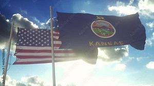 The Kansas state flags waving along with the national flag of the United States of America. In the background there is a clear sky