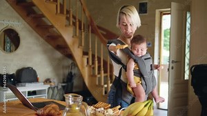 Woman born without arms with Phocomelia syndrome, multitasking Using laptop and eating while holding baby in baby carrier